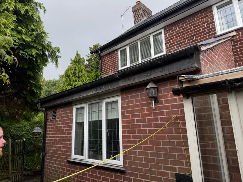 Old timber fascia boards with blistered, peeling paint along the roofline of a brick house in Adlington before replacement