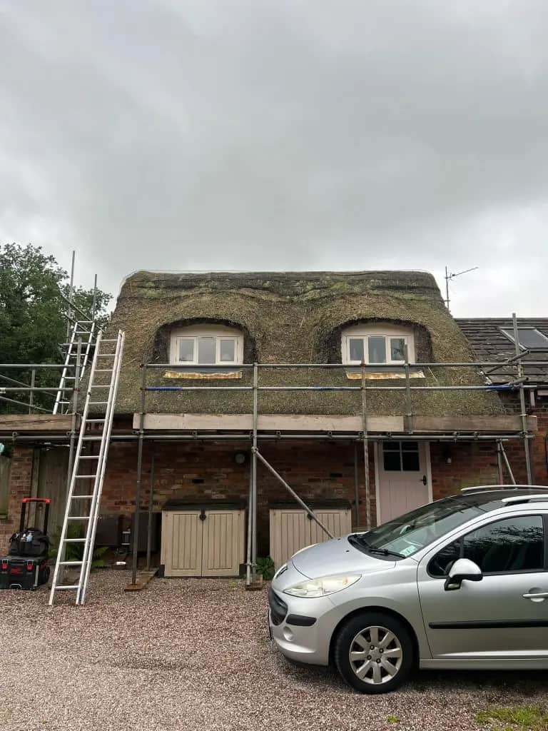 Aged water-reed thatch on a late 1700s Adlington cottage at end of life, fire risk and rising insurance premiums had made the original covering unworkable