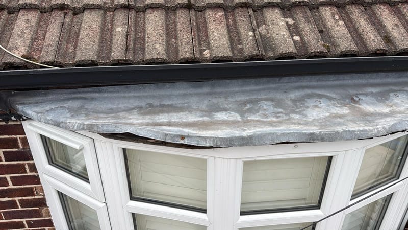 Old split and lifting lead on a period bay window roof before renewal in Cheadle Hulme