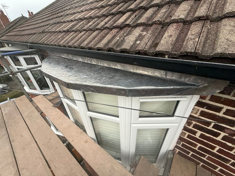 Fresh Code 5 lead sheet dressed over wood-core rolls on a bay window roof in Cheadle Hulme
