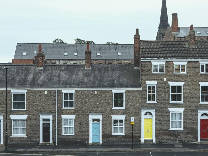 A row of British brick terraced houses with clean grey slate roofs