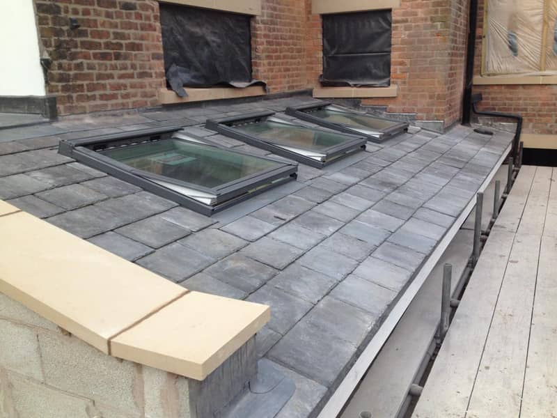 Three Velux roof windows installed on a slate pitched roof in Stockport