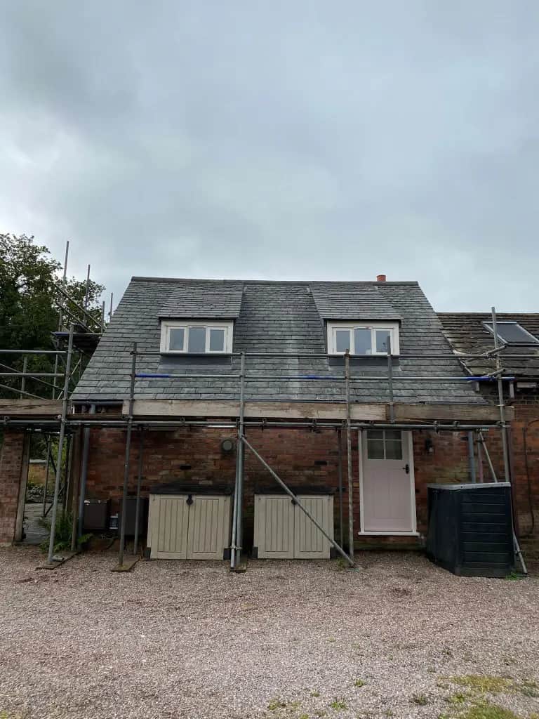 Late 1700s Adlington cottage re-roofed in Greys Artstone synthetic slate with ornamental ridge after a thatch-to-slate conversion, heritage character retained, lightweight covering preserved the original timber structure